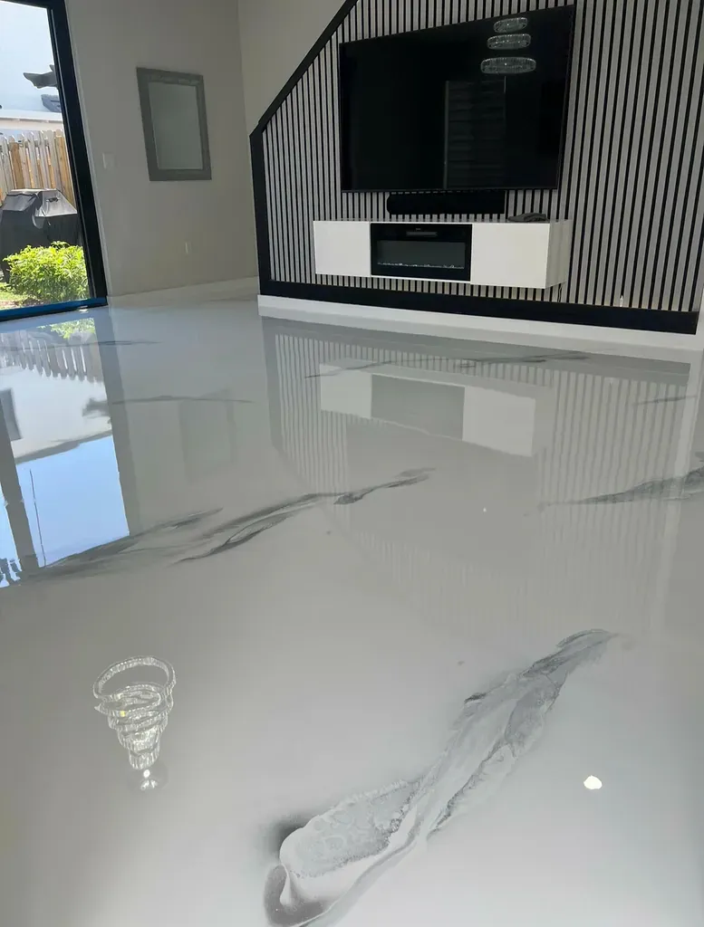 White and grey metallic epoxy floor in a living room with a slatted feature wall and mounted television