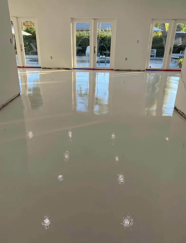 Empty residential room with a cream high-gloss epoxy floor and light coming through French doors