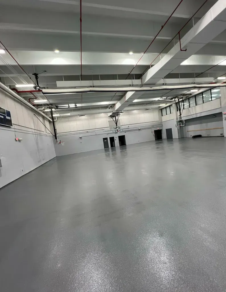 Covered parking level with a uniform grey coated floor and painted structural columns