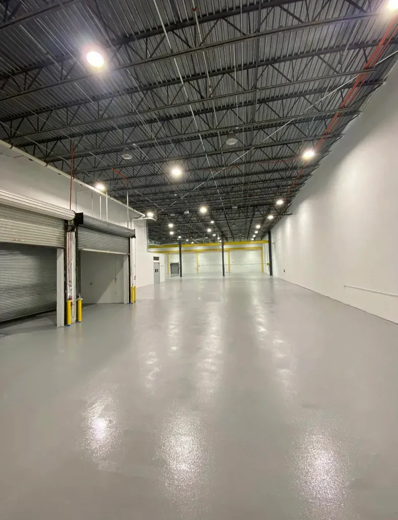Industrial warehouse with loading docks and a continuous grey resin floor running the full length