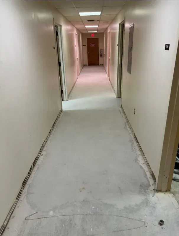 Bare concrete corridor ground down and ready for coating, walls still unfinished