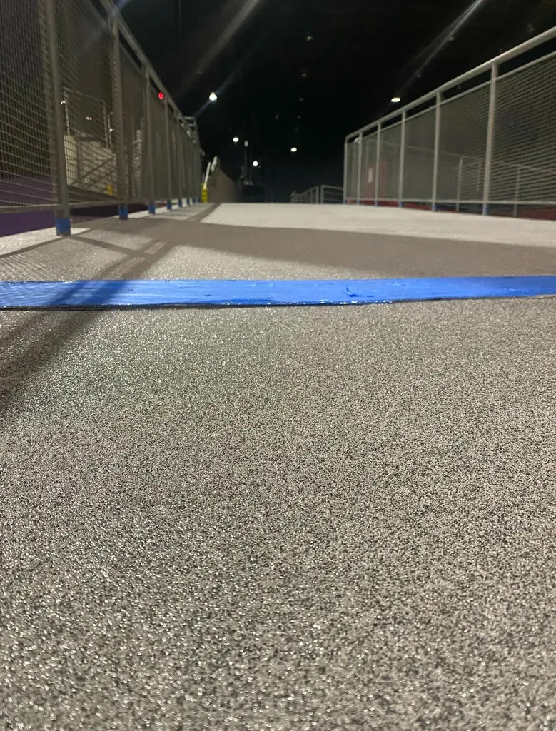 Grey flake epoxy floor with dense vinyl chip texture on an open terrace